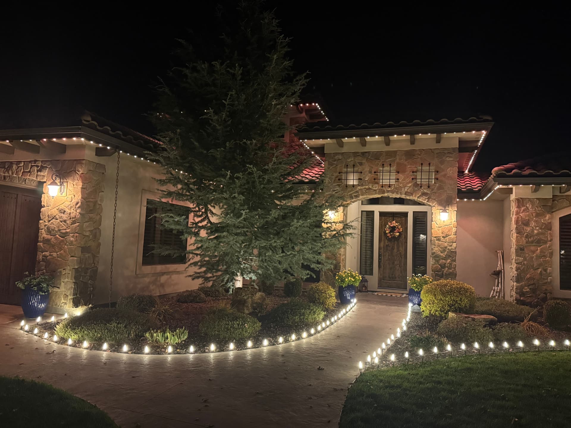 Warm white C9 pathway lights lining a curved walkway and front entry in Idaho