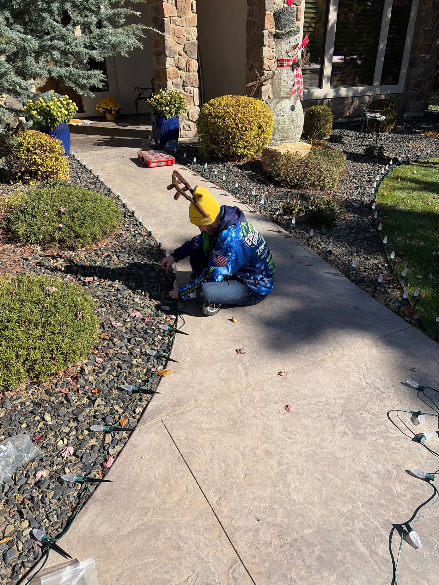 Installer staking C9 pathway lights along a front walkway